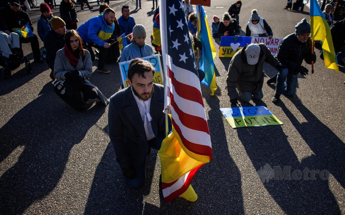 ORANG ramai melutut sebagai tanda sokongan kepada Ukraine dalam perhimpunan di depan Rumah Putih di Washington. FOTO AFP