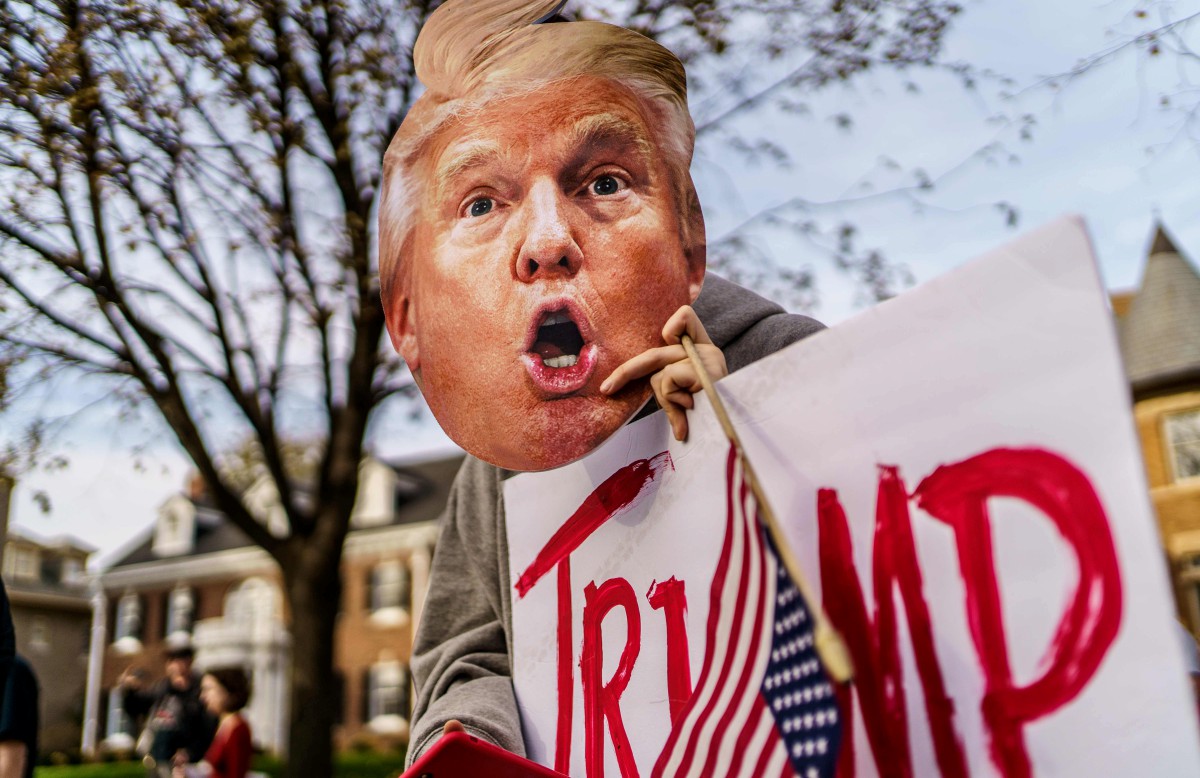 PENYOKONG Trump memakai topeng muka pemimpin itu ketika protes di hadapan kediaman Gobenor Minnesota Tim Walz pada Sabtu. FOTO AFP.