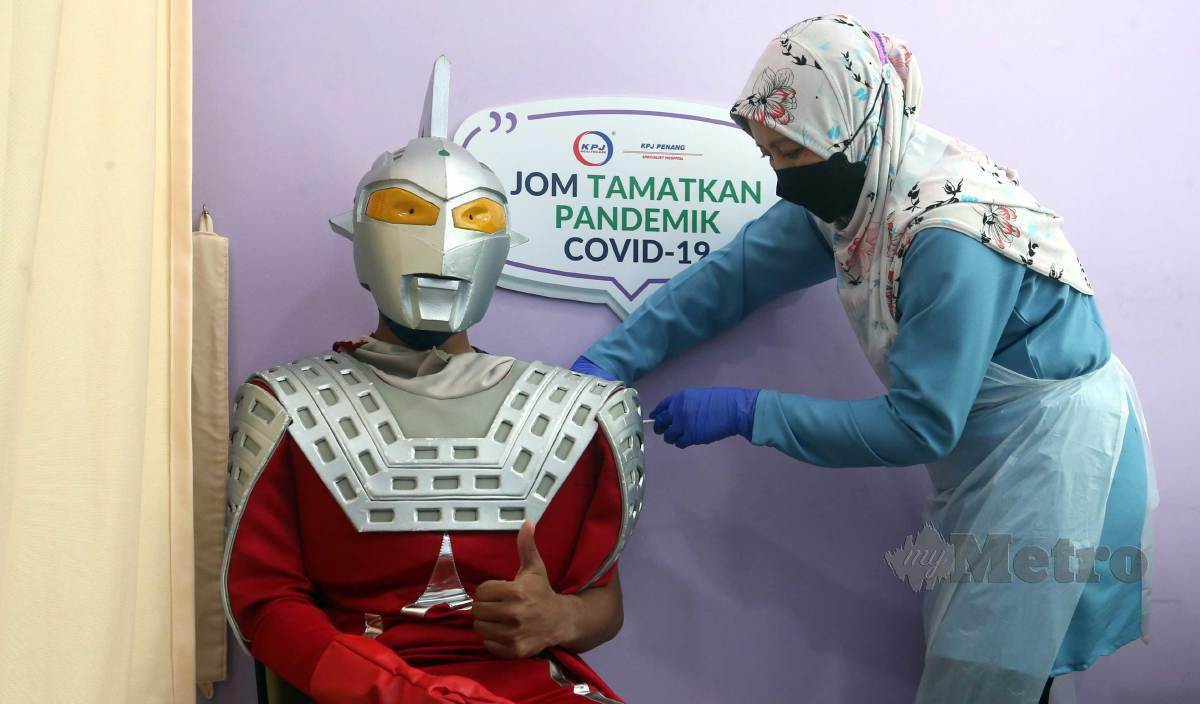 MOHAMAD Syukur memakai kostum Ultraman Ultraseven menerima suntikan vaksin Covid-19 di PPV Hospital Pakar KPJ Pulau Pinang, Bandar Perda. FOTO Danial Saad