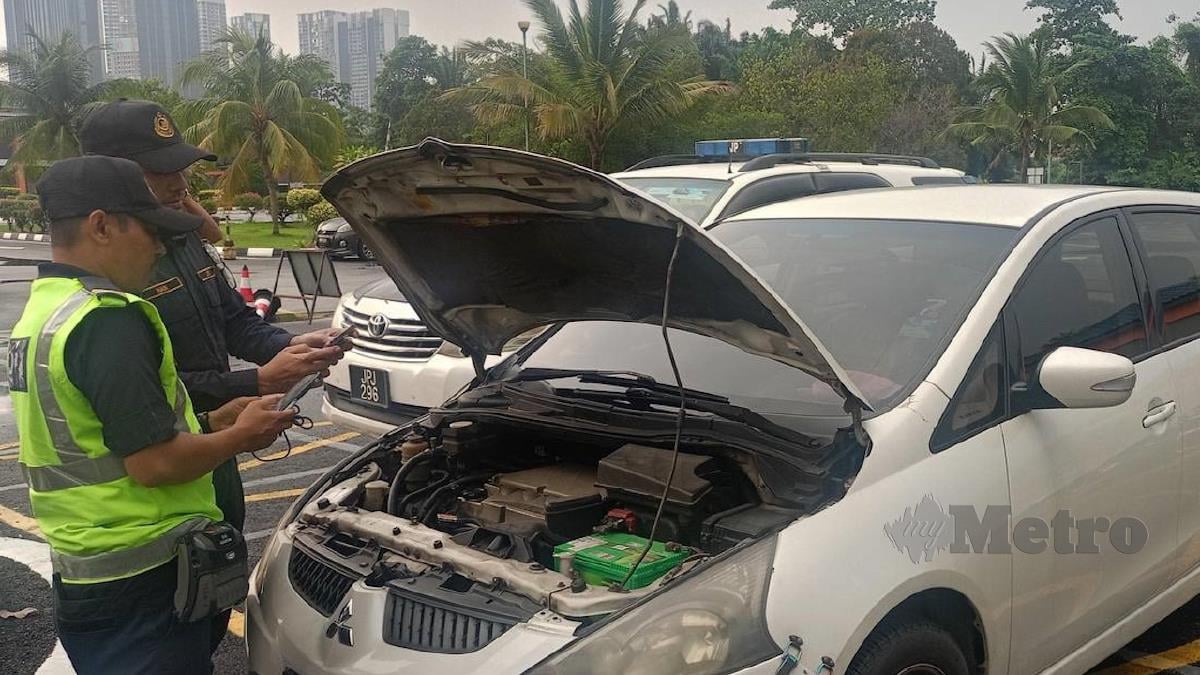 PEGAWAI JPJ Selangor memeriksa MPV Mitsubishi Grandis yang disyaki klon dan menggunakan nombor pendaftaran palsu. FOTO Ihsan JPJ