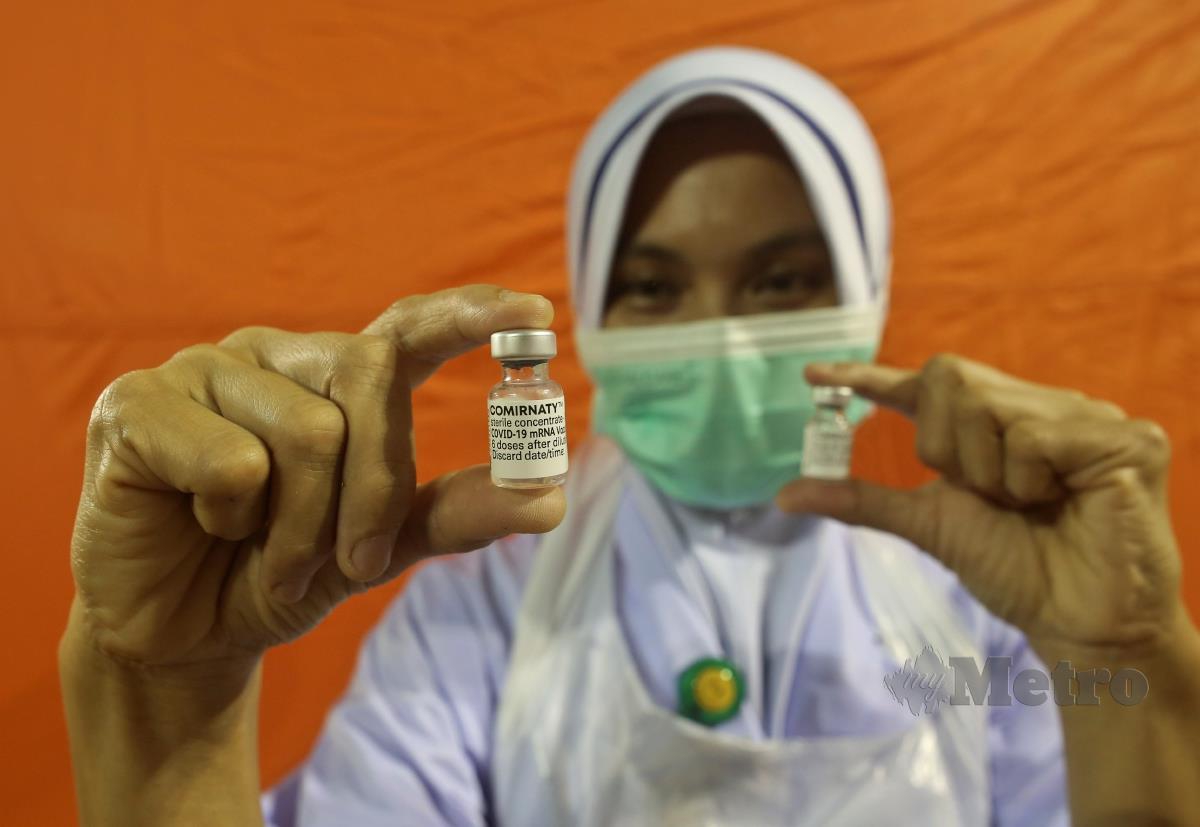 JURURAWAT, Rosmaria Yusof memegang vaksin Covid-19 Pfizer-BioNTech di Pusat Pemberian Vaksinasi (PPV)  di Stadium Tertutup Gong Badak, Kuala Nerus, semalam. FOTO GHAZALI KORI