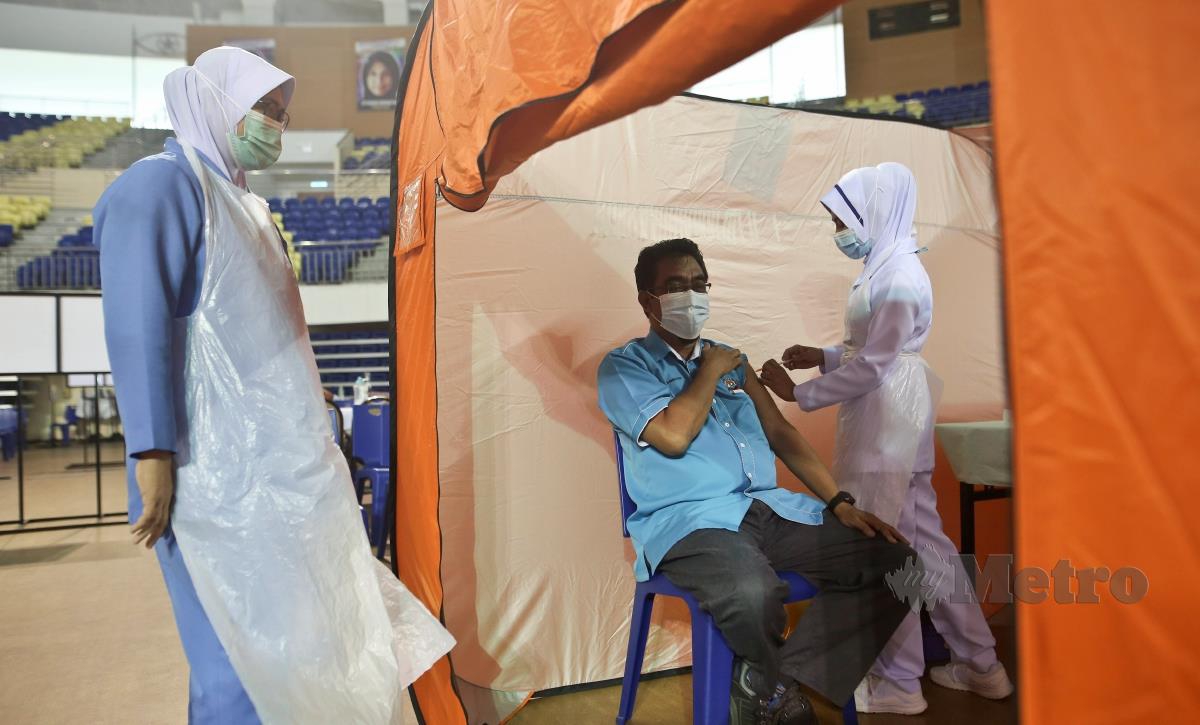 PENJAWAT awam menerima suntikan vaksin di Pusat Pemberian Vaksin (PPV) di Stadium Tertutup Gong Badak, Kuala Nerus. FOTO GHAZALI KORI