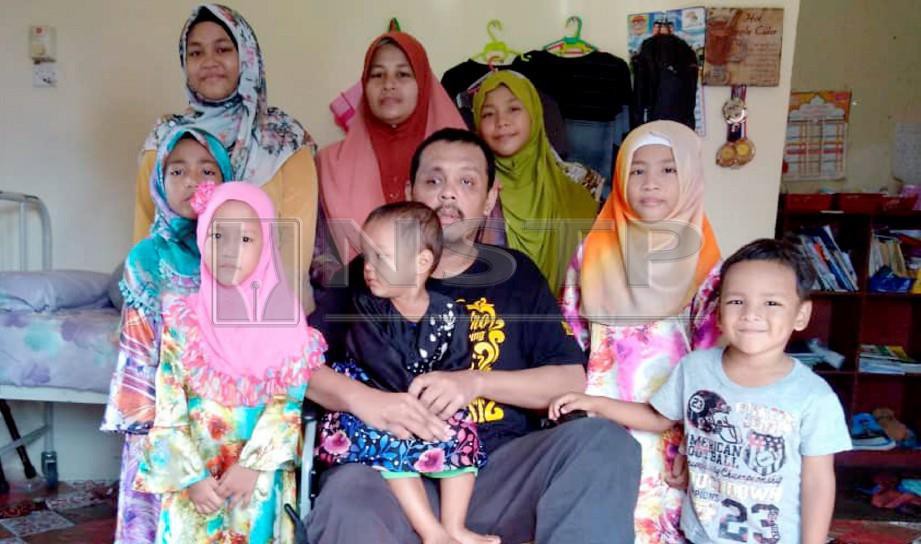 WAN Mohd Azraimie Wan Mohd Mohayidin, 42,  (berkerusi roda) bersama isteri dan anak-anaknya  ketika ditemui di rumahnya di Kampung Teluk Kitang. FOTO Hazira Ahmad Zaidi