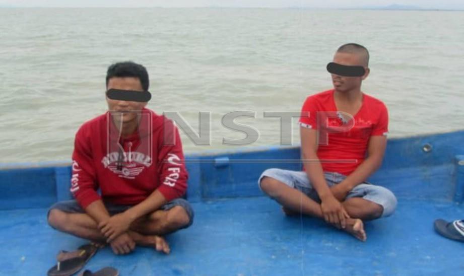 DUA lelaki warganegara asing ditahan Agensi Penguatkuasaan Maritim Malaysia (APMM) di Pengkalan Kuala Kurau. FOTO Ihsan APMM