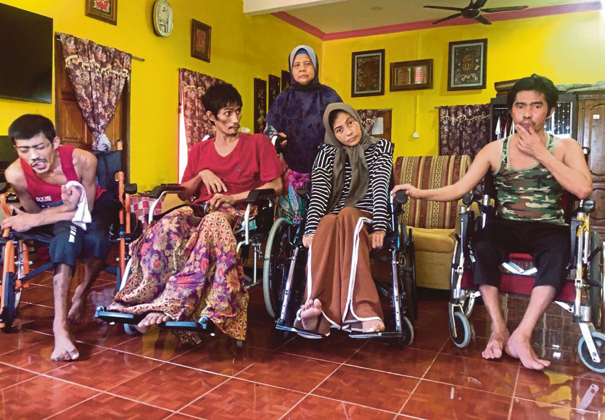 ROSANANI (berdiri) bersama empat anaknya yang lumpuh seluruh badan akibat penyakit saraf. FOTO Bernama.