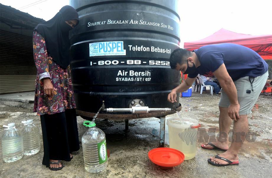 PENDUDUK sekitar Paya Jaras mengambil bekalan air dari lori Air Selangor berikutan gangguan bekalan air. FOTO Khairul Azhar Ahmad.