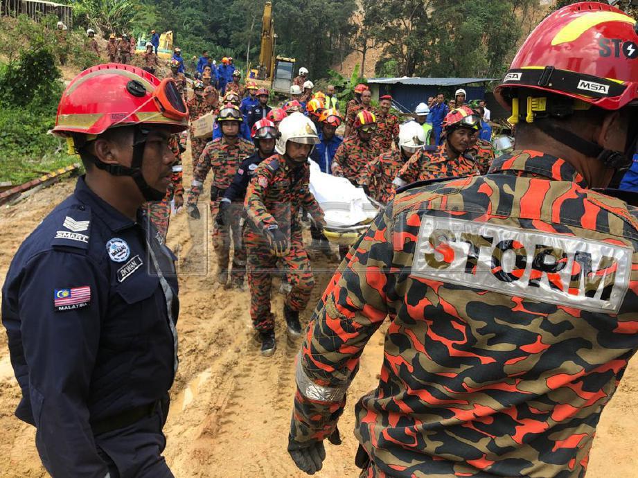 PASUKAN  Mencari dan Menyelamat Khas Malaysia (SMART) bersama Angkatan Pertahanan Awam Malaysia (APM) membawa mayat mangsa kelapan yang tertimbus dalam runtuhan di Bukit Kukus di Paya Terubong. FOTO Shahnaz Fazlie Shahrizal