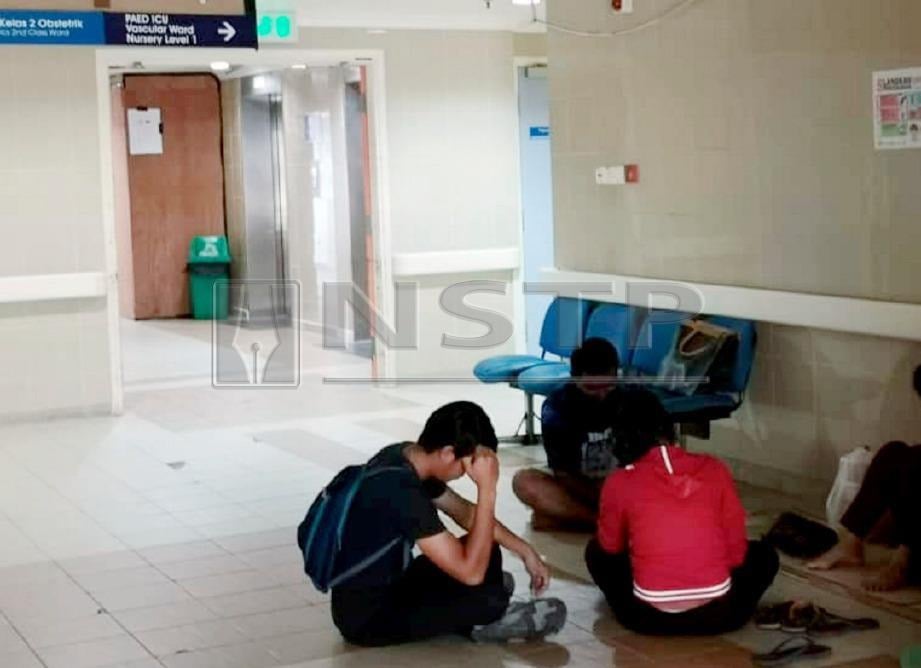 AHLI keluarga bayi yang koma selepas didera pengasuh menunggu di perkarangan unit rawatan rapi (ICU) Hospital Umum Sarawak (HUS) di Kuching. FOTO Ekhwan Haque Fazlul Haque