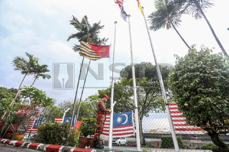 ANGGOTA Bomba dari Balai Subang Jaya, Elvin Elvister menurunkan bendera separuh tiang berikutan kematian anggota bomba, Muhammad Adib Mohd Kassim di Balai Bomba Subang Jaya. FOTO Muhd Zaaba Zakeria