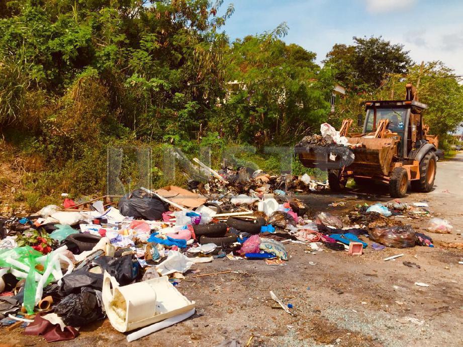 KERJA-KERJA pembersihan sedang dilaksanakan oleh pihak Alam Flora di kawasan pembuangan sampah haram di Kampung Bukit Setongkol di Kuantan. FOTO Shahrinnahar Latib