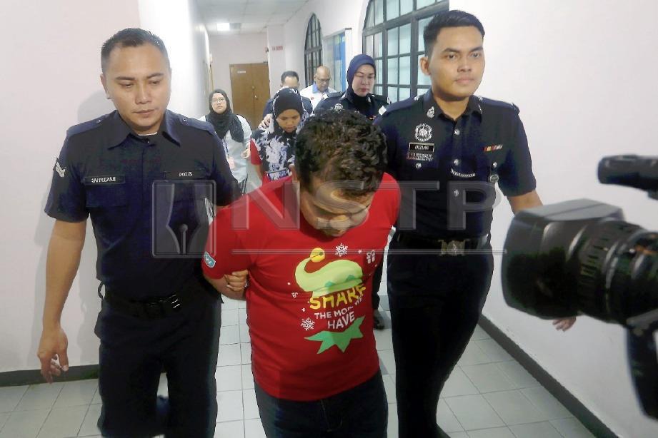 TERTUDUH, Muhammad Farid Rosli, (tengah) dan isteri, Yuliani Chosibah, 38, diiringi polis ketika dihadapkan ke mahkamah atas tuduhan mendera anak di Mahkamah Sesyen Johor Bahru. FOTO Hairul Anuar Rahim