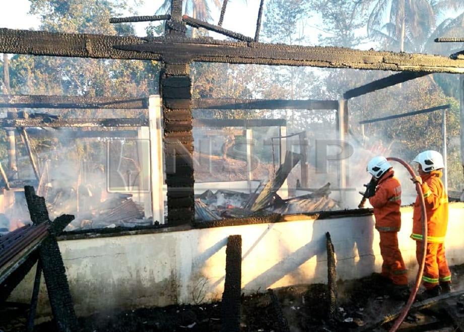 Anggota bomba memadam api yang memusnahkan sebuah rumah di Batu 11, Jalan Elopura di Sandakan. FOTO Ihsan JBPM Sabah