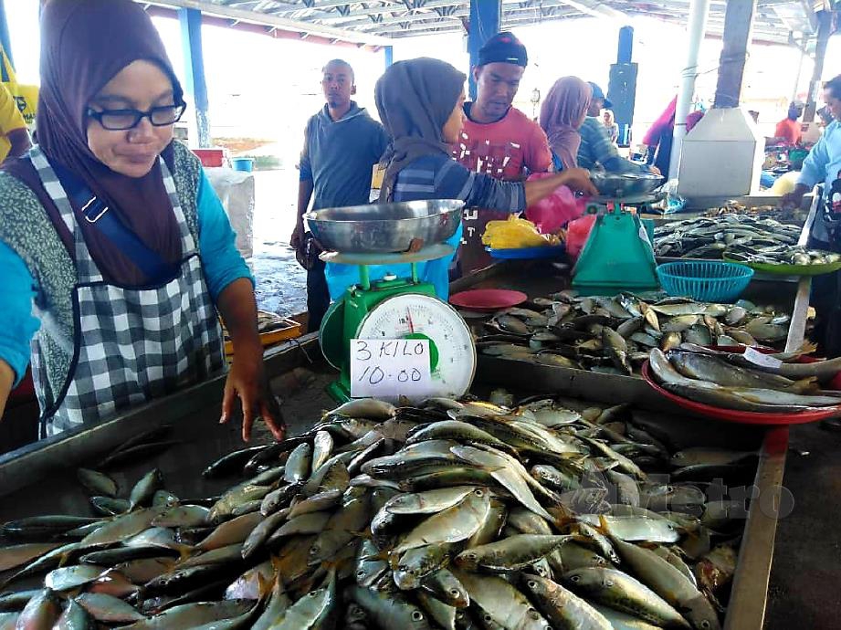 KHADIJAH Md Shah menjual ikan kembung pada harga RM10 untuk tiga kilogram di pelantar ikan Kampung Seberang Kota. FOTO Zuliaty Zulkiffli
