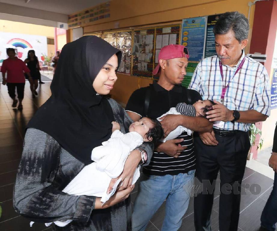 CALON Barisan Nasional, Datuk Seri Mohamad Hasan beramah mesra dengan pengundi Nur Izzati Abdul Gani, 30,  yang baru habis pantang bersama suami Mohd Fadil  ketika meninjau pusat undi  di SJKT Rantau pada Pilihanraya Kecil Dun Rantau. FOTO Saifullizan Tamadi