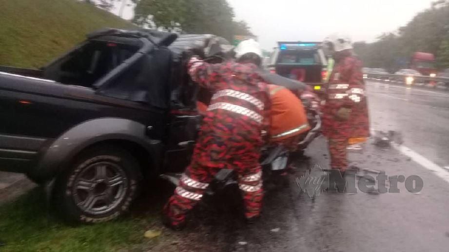ANGGOTA bomba mengeluarkan mangsa yang tersepit dalam kereta selepas kemalangan  membabitkan Nissan Frontier dan treler di Kilometer 21.1 Lebuhraya Utara Selatan (PLUS) arah selatan. FOTO Ihsan Bomba