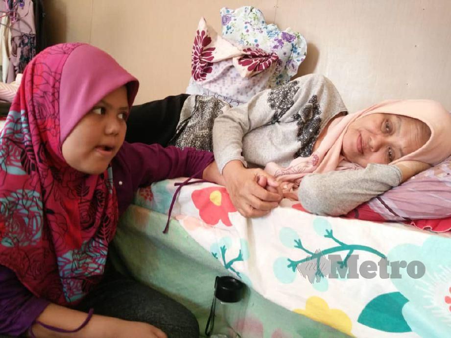 PESAKIT kanser ovari, Nur Nadira Balqis Abdul Khalid, 10, memegang tangan ibunya Siti Khalijah Che Hat, 51, yang masih kurang sihat selepas menjalani pembedahan membuang bisul di belakang tengkuk minggu lalu. FOTO Noorazura Abdul Rahman