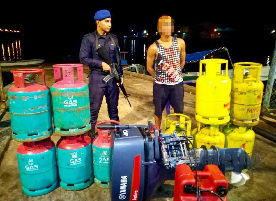 SUSPEK lelaki tempatan ditahan Pasukan Polis Marin (PPM) dalam Ops Gelora Khas disyaki cuba menyeludup keluar 10 tong gas cecair petroleum (LPG) di kawasan perairan Sungai Haji Kuning, Pulau Sebatik di Tawau. FOTO Ihsan PPM