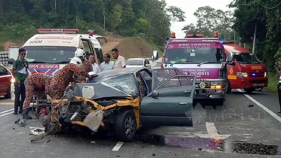 ANGGOTA bomba mengeluarkan mangsa kemalangan membabitkan kereta Toyota Corona dan lori Scania di Kota Tinggi. FOTO Ihsan Bomba 