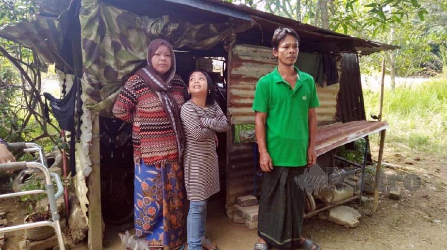 BAKRI Md Razali bersama isteri dan seorang anak mereka dihadapan reban ayam yang dijadikan tempat tinggal untuk berteduh di Kampung Badang,  Mukim Bakai, Baling. FOTO Safuri Kamarudin