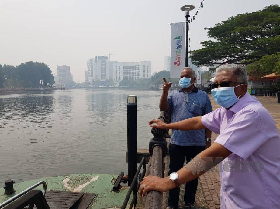 PELANCONG dari Pulau Pinang, Mohd Ghouse Mohamad Shah, 64 dan Tajul Ariffin Md Eusoff, 64 melawat Tebingan Kuching walaupun kualiti udara di Bandaraya Kuching menunjukkan IPU  tidak sihat. FOTO MOHD RADZI BUJANG
