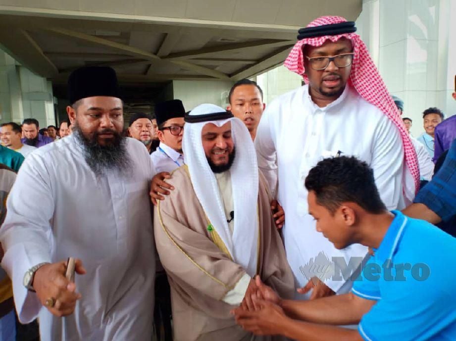 SYEIKH Misyari Rasyid (tengah) bersalaman dengan jemaah selepas solat Jumaat, di Masjid Sultan Mizan  Zainal Abidin. FOTO Samadi Ahmad