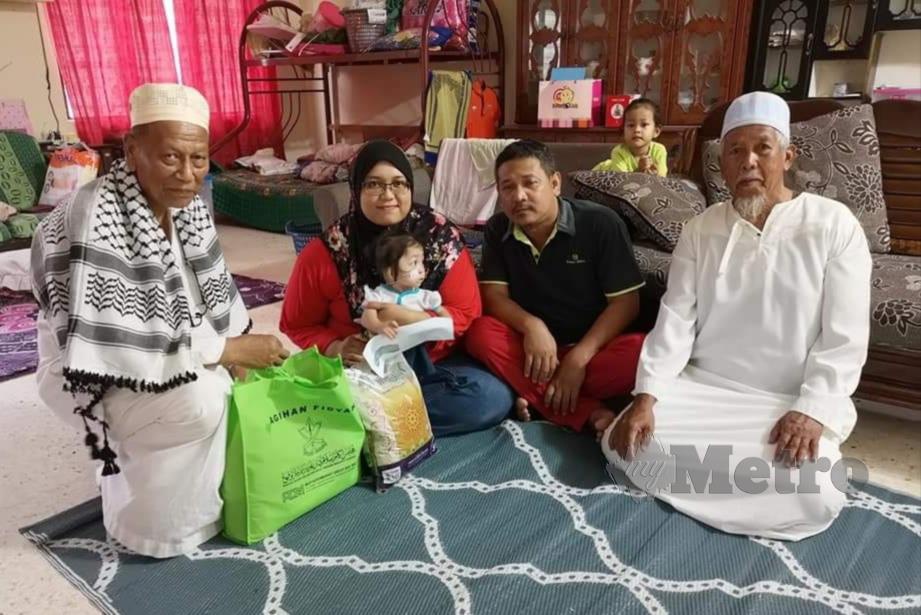 IKHTIMAN (kiri) menyampaikan sumbangan wang tunai dan barangan keperluan harian kepada pasangan Siti Norzurain Fatima dan Ahmad Zainuddin (dua dari kanan). FOTO Roselan Ab Malek