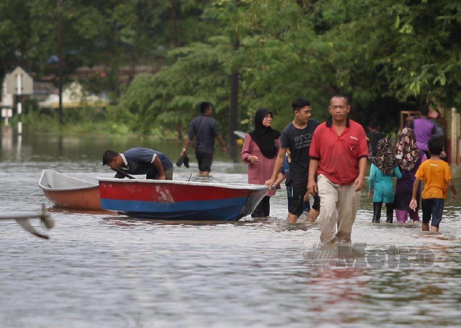 JALAN Rantau Panjang Lama di Kampung Pohon Tanjung di tutup kepada semua lalulintas kerana limpahan air dari Sungai Golok berikutan hujan yang turun selama enam hari tanpa henti di Kelantan. FOTO Fathil Asri