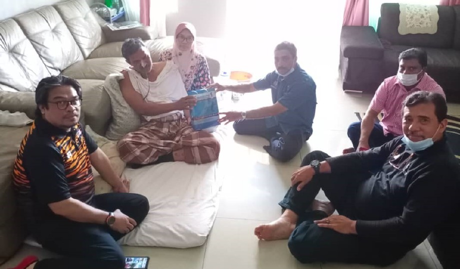 NOORUL Ariffin menyampaikan sumbangan kepada Ahmad Sofian sambil diperhatikan isterinya, Hamizah dan skuad Yakeb Prihatin di Ipoh, hari ini. FOTO Ihsan Yakeb