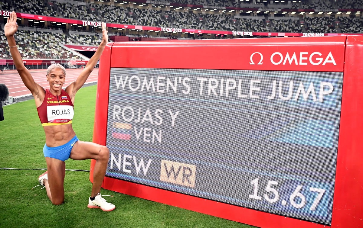 Pemenang pingat emas acara lompat kijang wanita, Yulimar Rojas dari Venezuela bergambar di depan catatan rekod dunia yang dilakukan di Sukan Olimpik Tokyo 2020. FOTO EPA
