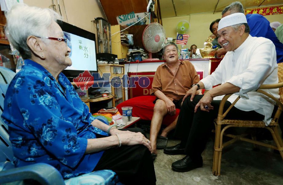 TIMBALAN Perdana Menteri, Datuk Seri Dr Ahmad Zahid Hamidi menziarah Ong Wan Heng, 61, (tengah) yang patah kaki sambil diperhatikan ibu Ong Wan Heng, Tan Yok Kuan, 87, (kiri) di Kampung Batu 24, Simpang Tiga, Bagan Datuk. FOTO NSTP/MUHAIZAN YAHYA