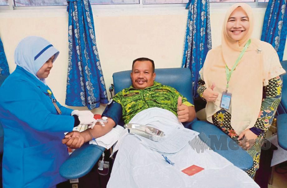 ZAKARIA (tengah) menderma darah kali ke-200 sambil diperhatikan Dr Azhani (kanan) di Unit Tabung Darah (UTD) HSNZ, Kuala Terengganu. FOTO Ahmad Rabiul Zulkifli.