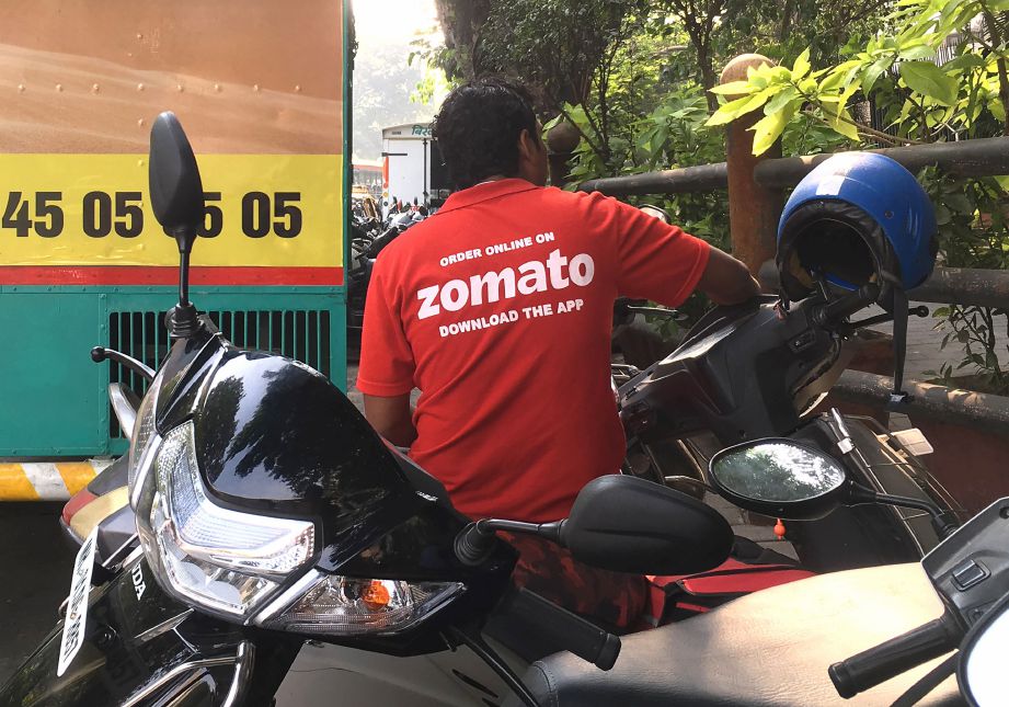 SEORANG penghantar makanan Zomato duduk di atas motosikal miliknya di Mumbai. FOTO AFP