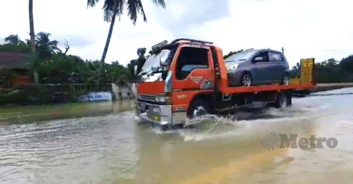 TRAK tunda membantu pengguna jalan raya yang terkandas banjir. FOTO Rosli Ilham