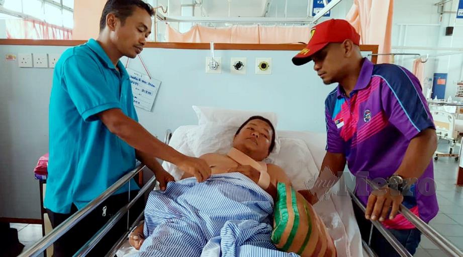 ZULKIFLY (kiri) menjaga Mohd Zaidan yang kini terlantar di Hospital Melaka selepas patah lima tulang rusuk akibat terjatuh ke dalam longkang berikutan dikejar anjing. FOTO Khairunisah Lokman.