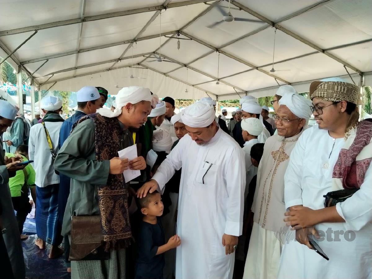 Nassuruddin Daud beramah mesra dengan guru pondok dan pelajar pondok yang hadir pada Program Sambutan Maulidur Rasul Perdana 1445H di Kompleks Guru-Guru Pondok Negeri Kelantan di Kampung Cherang Tuli, Padang Pak Amat di sini, hari ini. FOTO Hidayatidayu Razali.