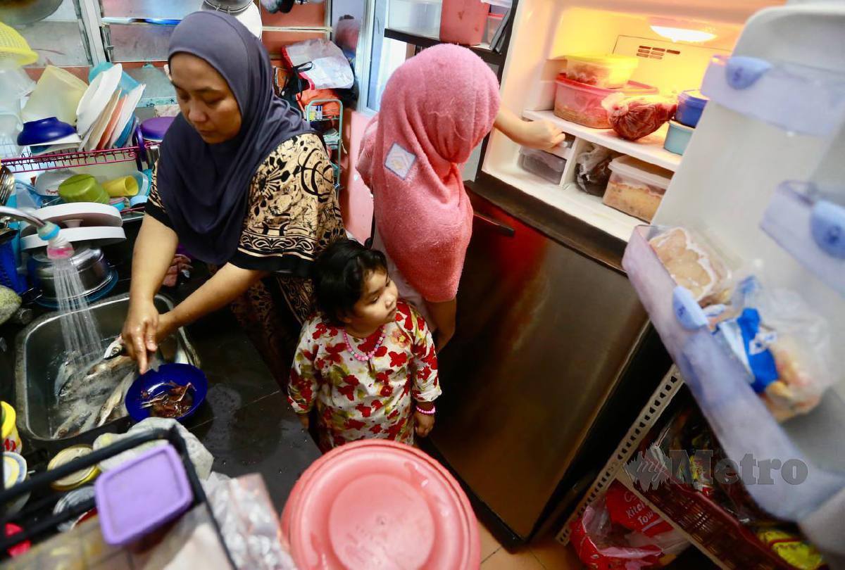 ZALIDA Syuhana (kiri) dibantu anaknya, Nurul Erra Fatini Syamsul membuat persiapan memasak sempena sambutan Aidilfitri. FOTO Fathil Asri