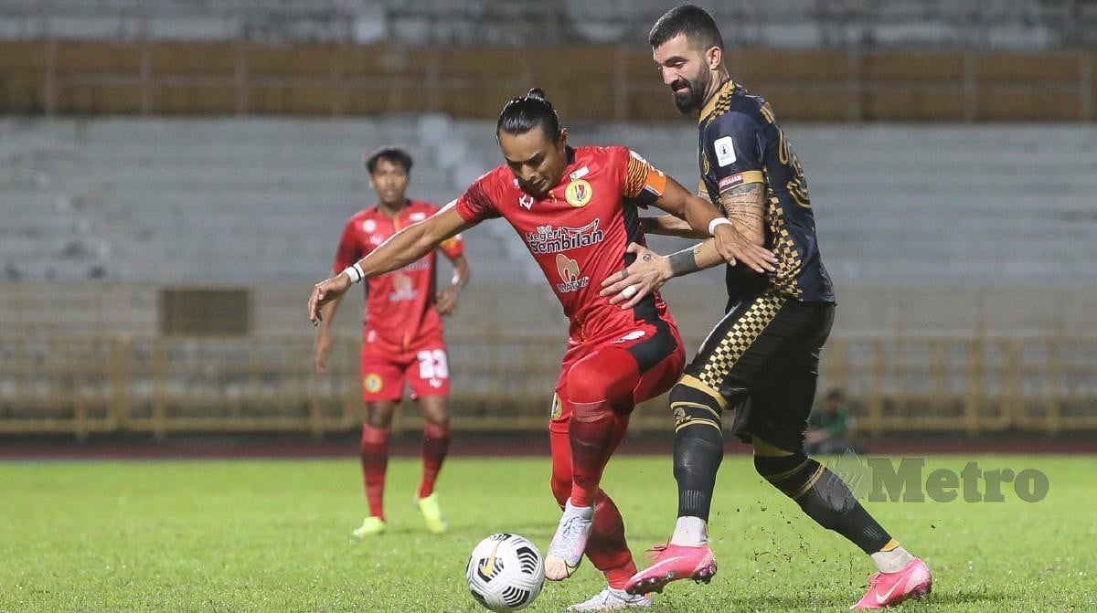 PEMAIN Negeri Sembilan FC, Zaquan Adha (tengah) mengasak pemain Kelantan FC, Christos Intzidis (kanan) ketika menentang Kelantan FC di Stadium Tuanku Abdul Rahman,Paroi. FOTO AZRUL EDHAM MOHD AMINUDDIN