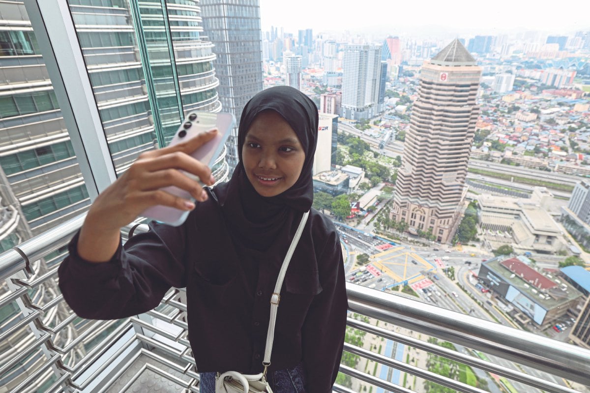 SITI Zubaidah berswafoto di jambatan tingkat 42 yang menghubungkan Menara Berkembar Petronas (KLCC). FOTO BERNAMA
