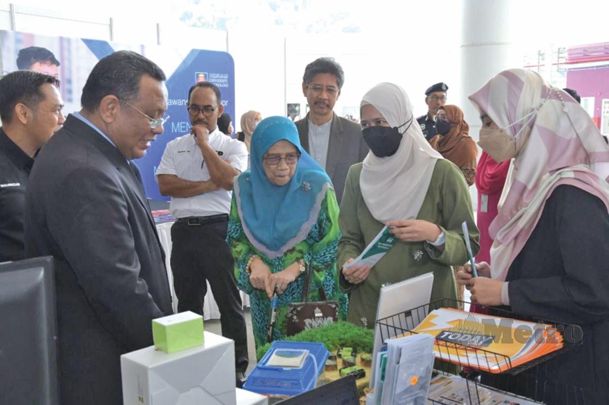 PROF Emeritus Datuk Dr Nik Safiah Karim  (dua dari kiri) dan Dr Mohd Sazili (kiri) melawat tapak pameran konvensyen.