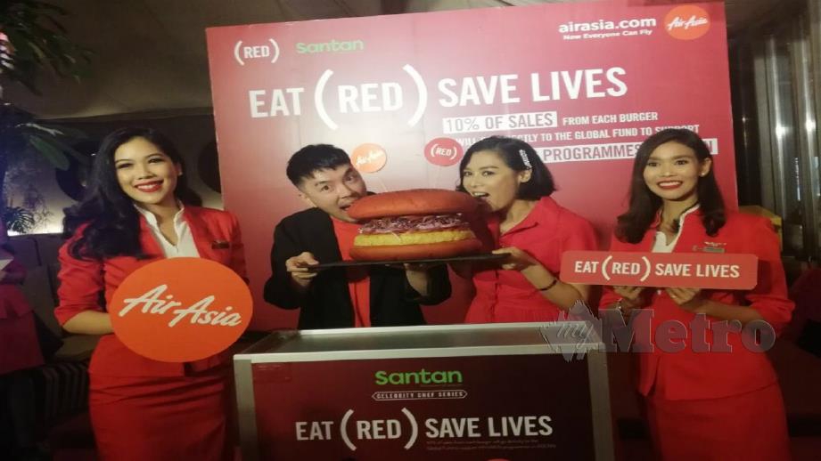 Rudy (dua dari kiri ) dan Chef Hong (dua dari kanan) menggigit burger sebagai simbolik pelancaran Burger INSPI (RED) untuk menu baru dalam pesawat AirAsia di Escape, Bangkok, hari ini. Foto Redzuan Muharam