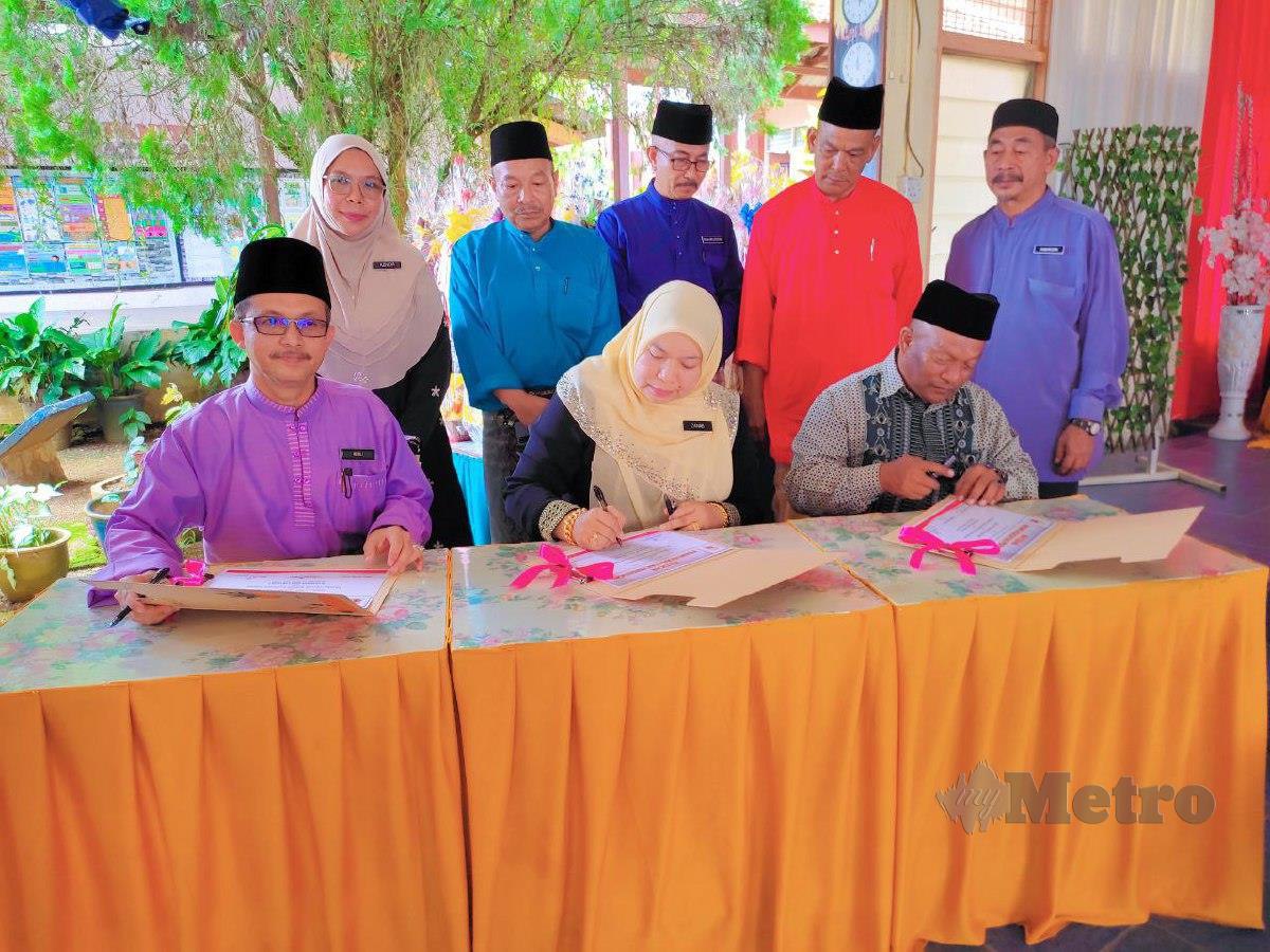 ROSLI (Duduk, kiri) turut menyaksikan Majlis menandatangani Watikah Permuafakatan Pendidikan antara SK Keruak dengan Felcra Berhad Kawasan Keruak.