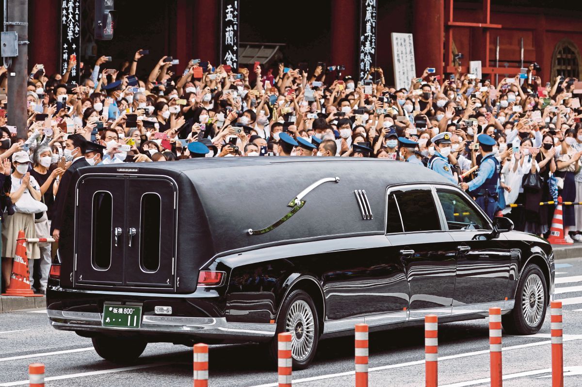 ORANG ramai menyaksikan kenderaan membawa jasad Abe meninggalkan kuil Kuil Zojoji, Tokyo. FOTO Reuters