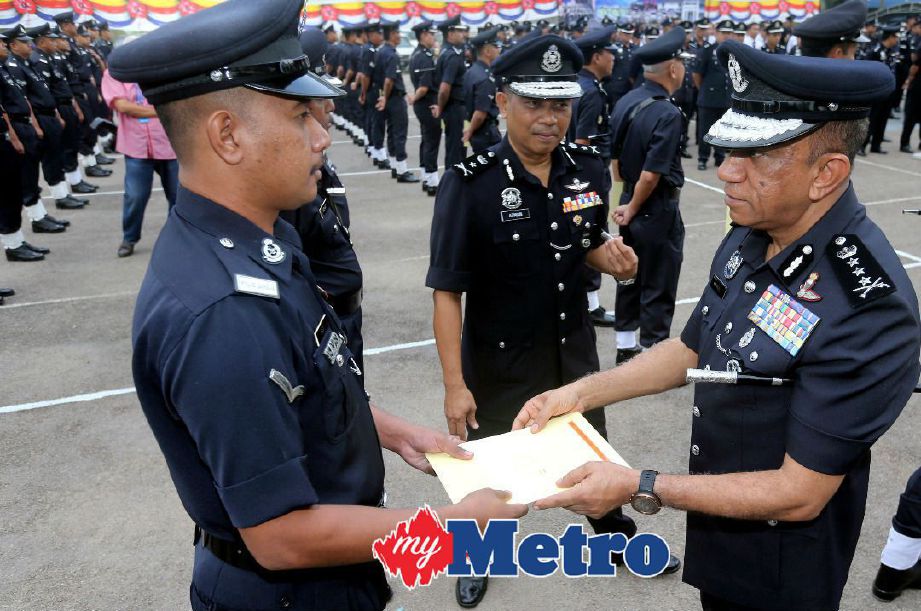 Mohd Khalil (kanan) menyampaikan sijil penghargaan kepada pegawai dan anggota polis berkhidmat dengan cemerlang selepas berucap pada majlis Perhimpunan Bulanan Polis Peringkat Ibu Pejabat Kontinjen Johor di Johor Bahru. Foto Zain Ahmad