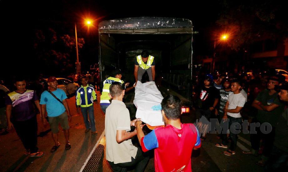 ANGGOTA polis dan orang awam mengangkat mayat Ku Muhammad Arshad untuk dibawa ke Hospital Melaka. FOTO Rasul Azli Samad