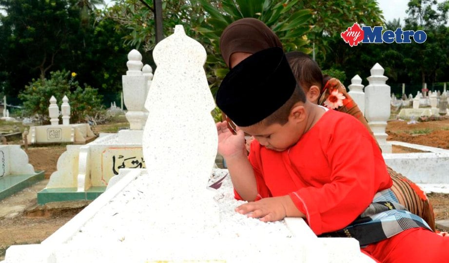 PUTRA Adam di sisi pusara arwah ibunya di Tanah Perkuburan Islam Padang Sebang. FOTO Norizzah Baharudin