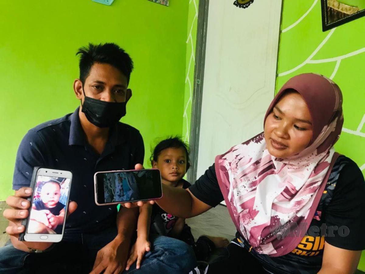 NURUL Asyikin dan suaminya Mohamad Zainal menunjukkan gambar Adam. FOTO Noorazura Abdul Rahman