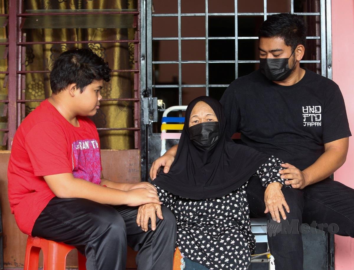 Muhammad Haidir (kanan) gembira bersama neneknya Faridah (tengah) yang baru selesai menjalani kuarantin di Hospital Tampin akibat Covid-19 ketika ditemui dirumahnya di Bandar Sunggala. FOTO AZRUL EDHAM MOHD AMINUDDIN