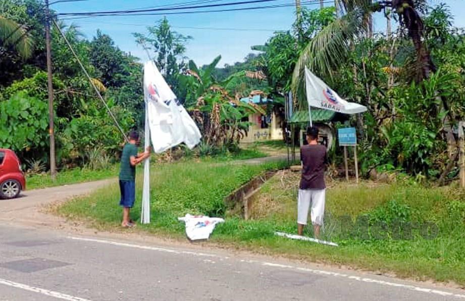 KERJA pemasangan bendera Parti Warisan Sabah (WARISAN) giat dijalankan di Kampung Langsat, Kimanis. FOTO NORASIKIN DAINEH.