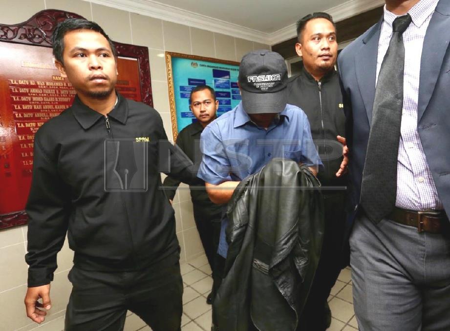 ADUN Terengganu (tengah) bergelar Datuk  dibawa ke mahkamah sebelum direman selama tiga hari bermula hari ini. FOTO Ghazali Kori