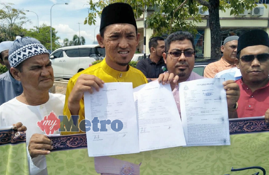 Nor Azam (dua dari kiri) menunjukkan laporan polis yang dibuat mereka terhadap UMNO Perlis. FOTO Dziyaul Afnan Abdul Rahman